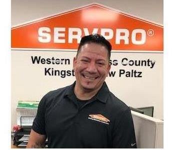 A photo of a smiling male employee wearing a black SERVPRO shirt.