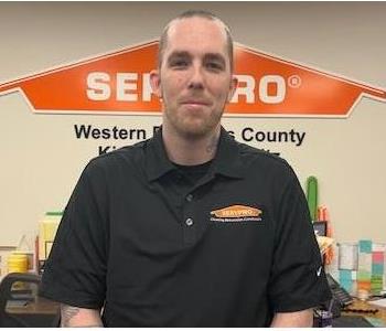 A photo of a smiling male employee wearing a black SERVPRO shirt.